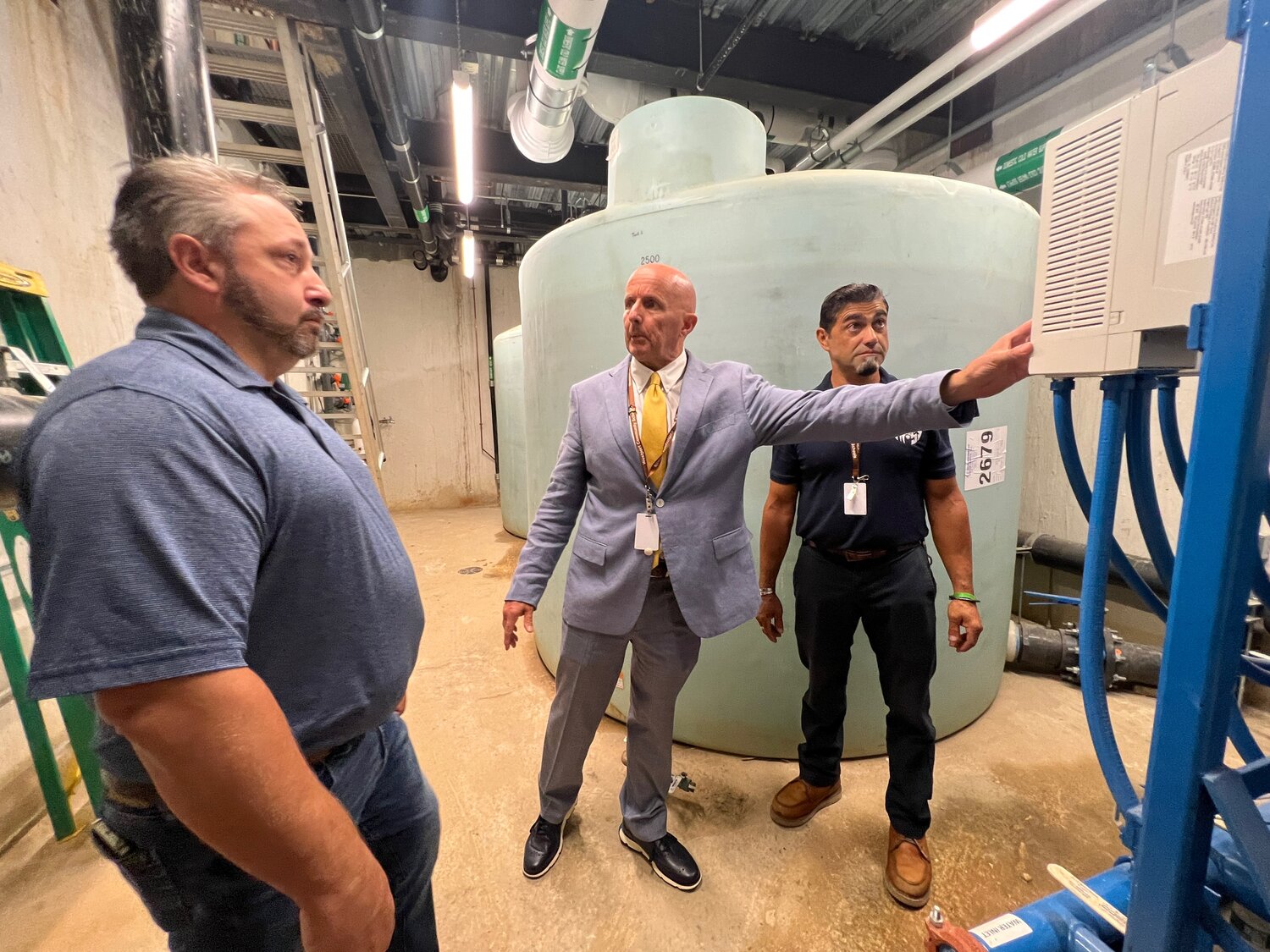 Superintendent Thomas Aubin (center) inspects one of the Middle/High School's two 3,000-gallon tanks Wednesday afternoon. At left is Public Health Director Matt Armendo and at right, Manny Moniz, the district's facilities director.