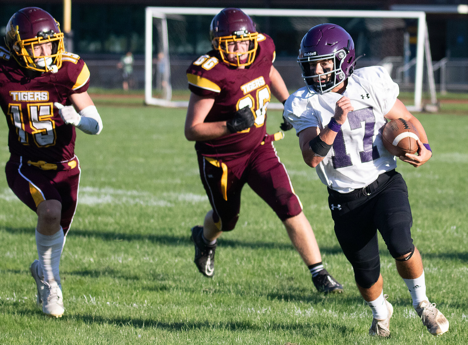 Running back Riley Howland speeds by Tiverton defenders on outside run.