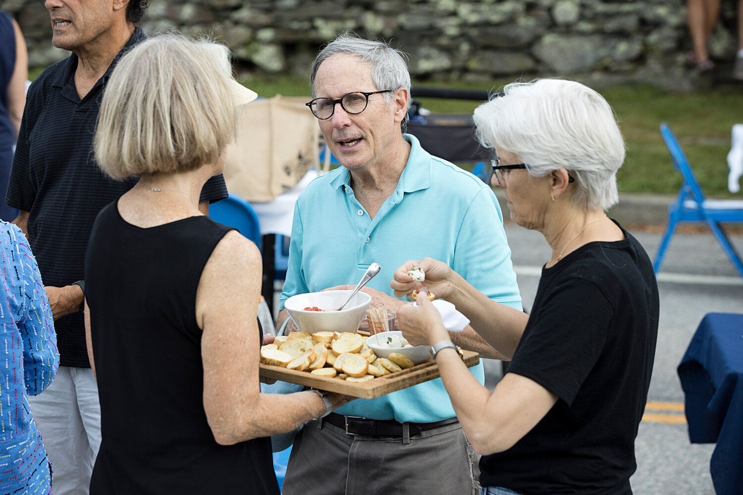 Friends share appetizers while waiting for the dinner bell to ring at Sunday's community dinner on the Commons in Little Compton.