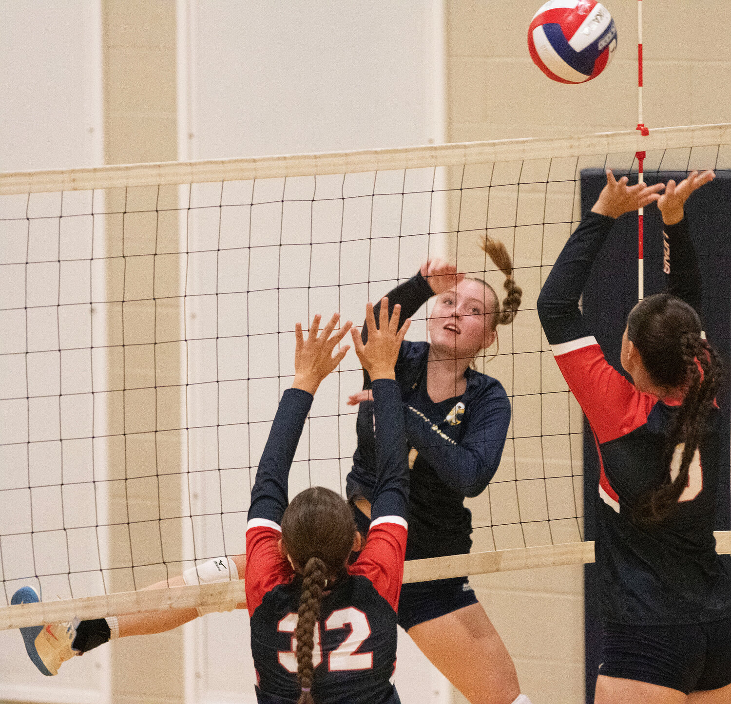 Barrington High School’s Emma McCrann spikes the ball past a pair of Lincoln defenders.