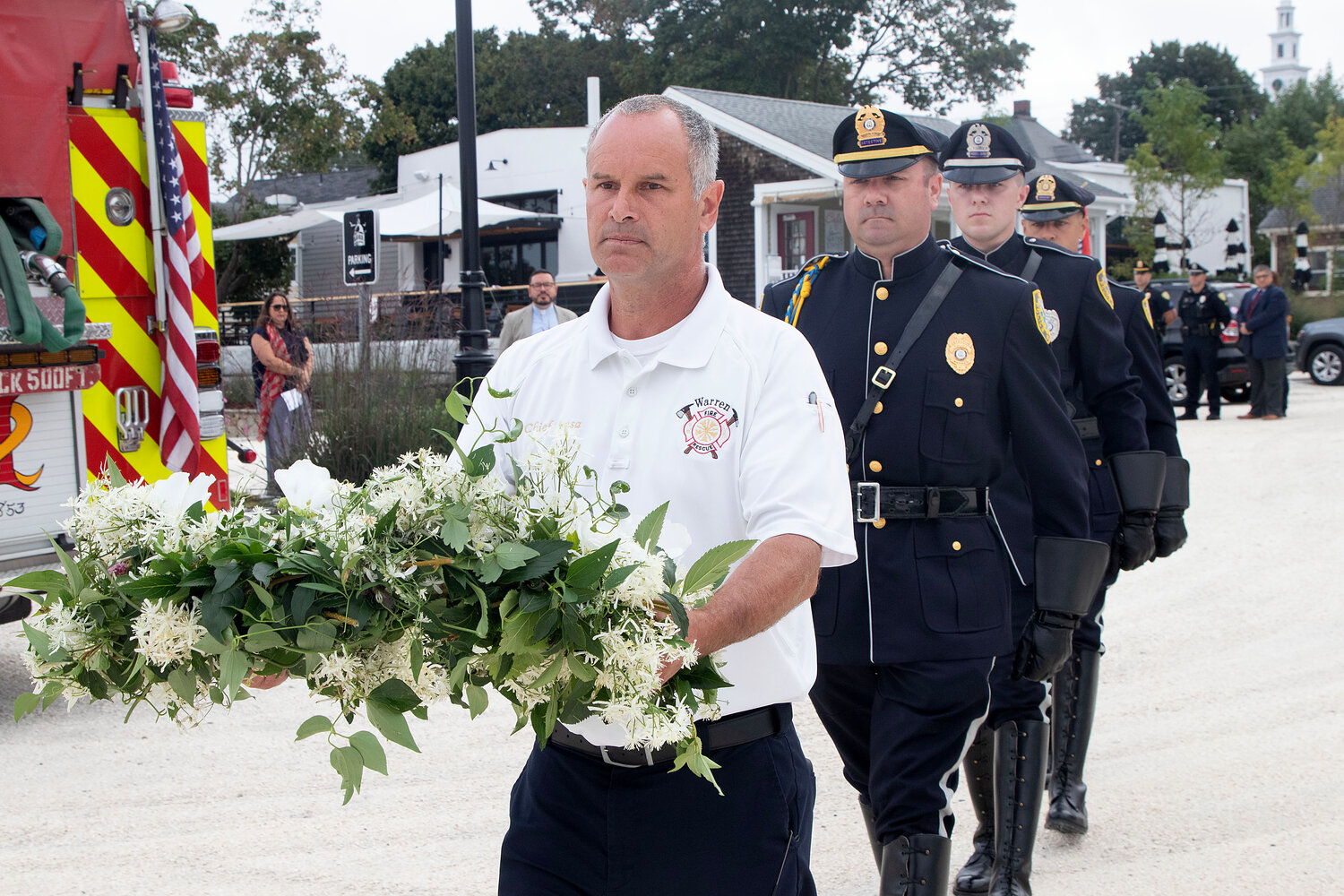 Fire Chief James Sousa walks towards the water to place a memorial wreath into the river in remembrance of those who perished on Sept. 11, 2001.