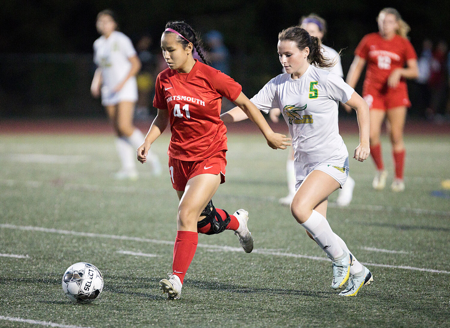 Elena Sun is pressured by a North Smithfield defender while controlling the ball for Portsmouth.