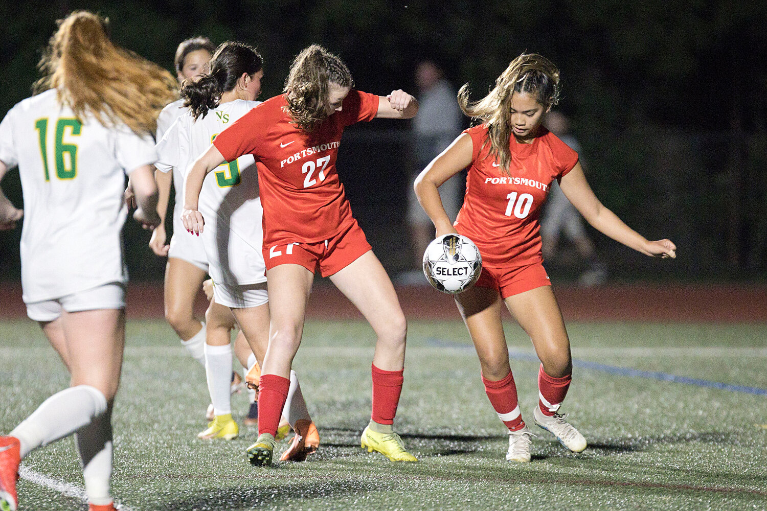 Lexi Owen (left) and Kylie Delemos work to settle a pass in front of the goal.