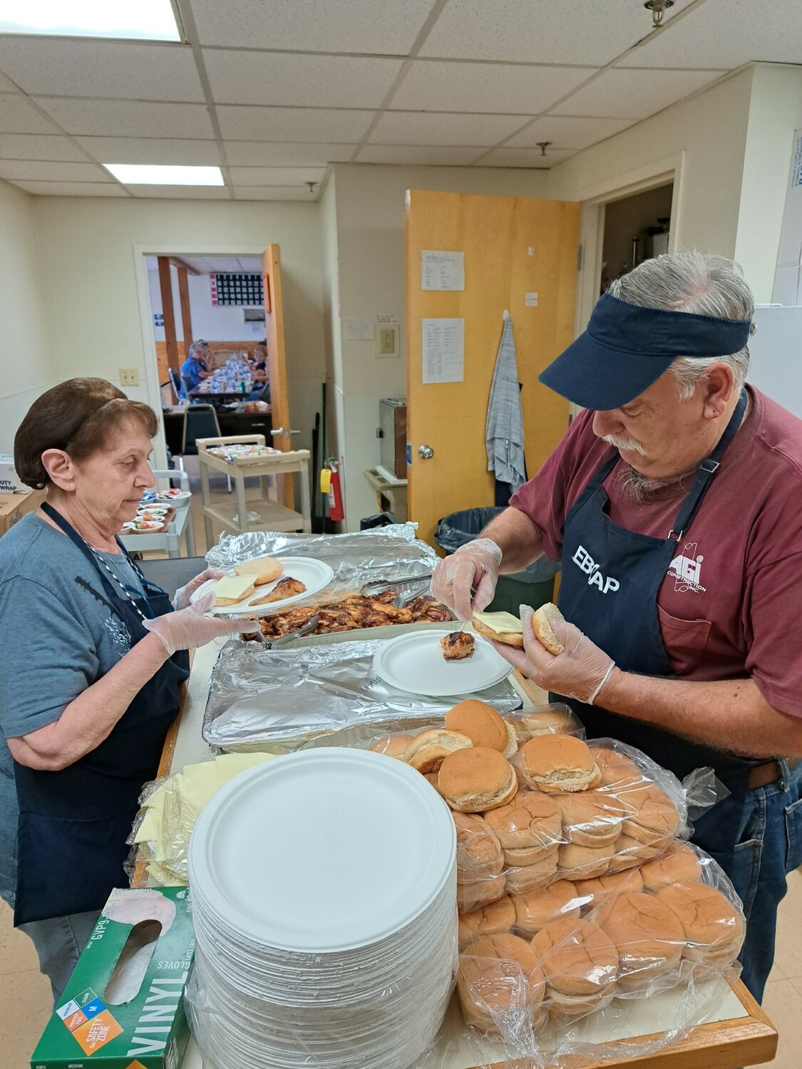 Warren Senior Center kitchen manager Ann Primiano (left) and nephew Bob Sousa were busy preparing for the Center's annual picnic which had to be moved indoors because of threatening weather reports.