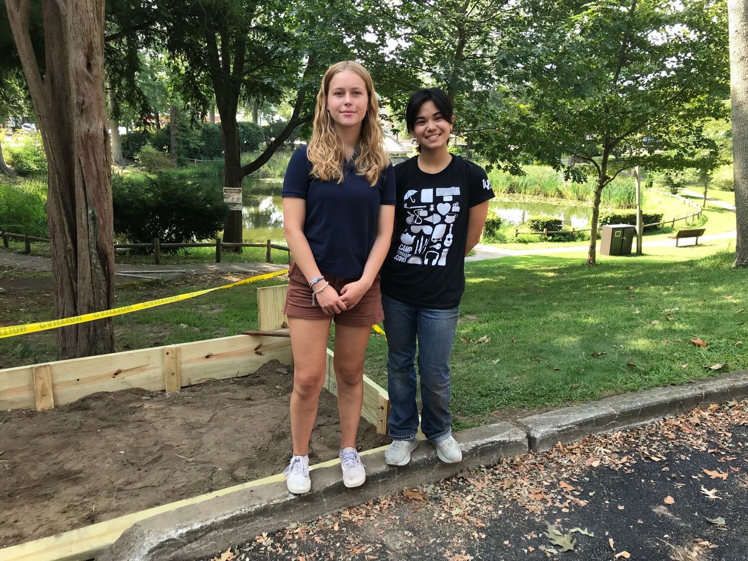 Barrington High School’s Emma Pautz (left) and Sabine Cladis stand at the site of the new compost drop-off location near the Barrington Senior Center parking lot.