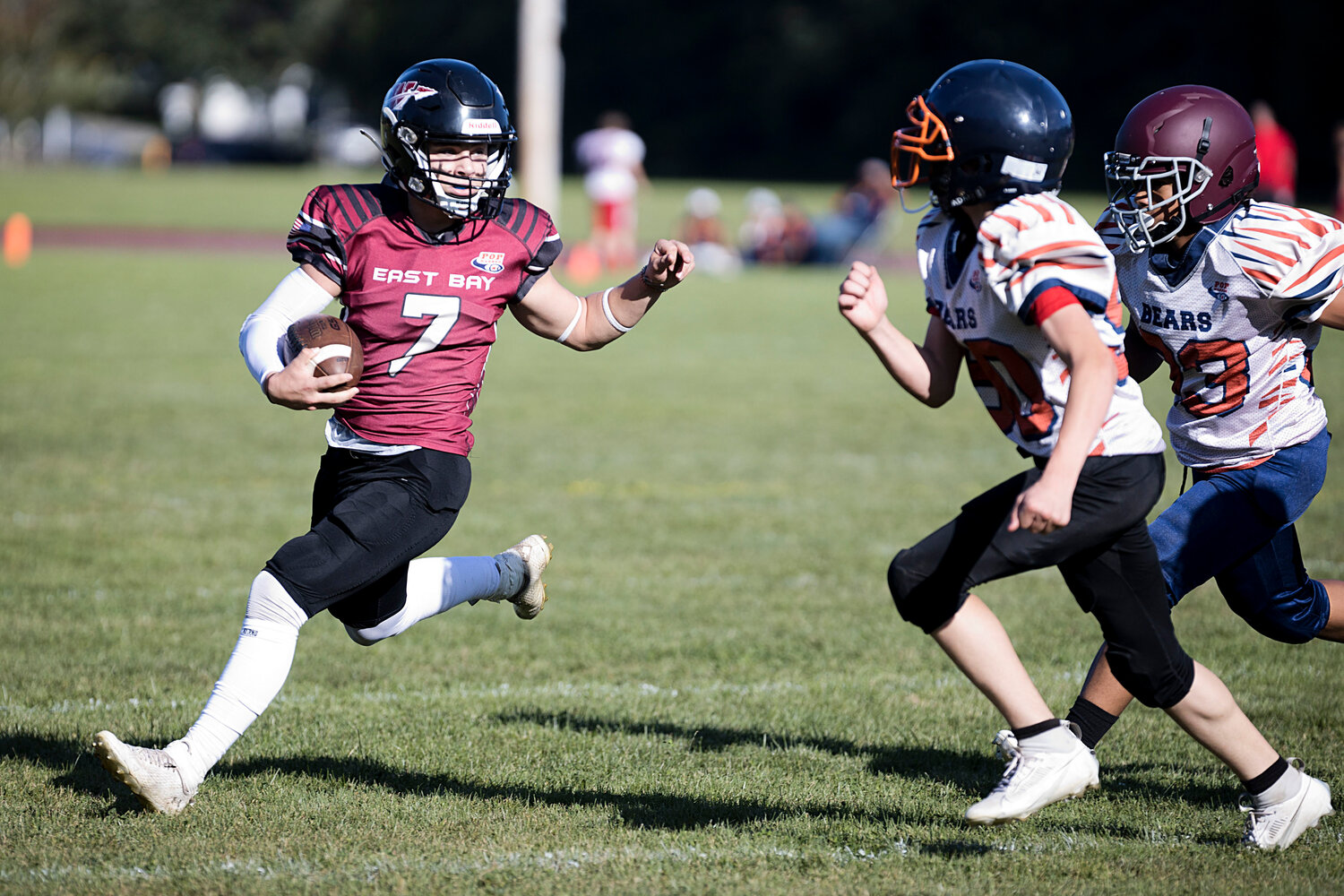 14U's Tyler Rhynard runs around the New Bedford defense while carrying the ball for East Bay. 