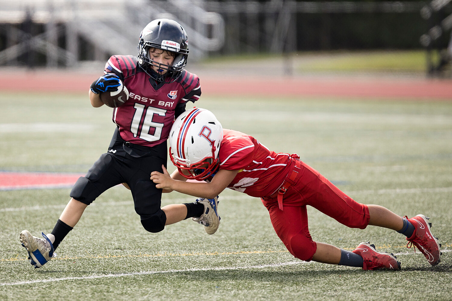 8U player, Levi Coelho breaks a tackle running the ball against Portsmouth. 