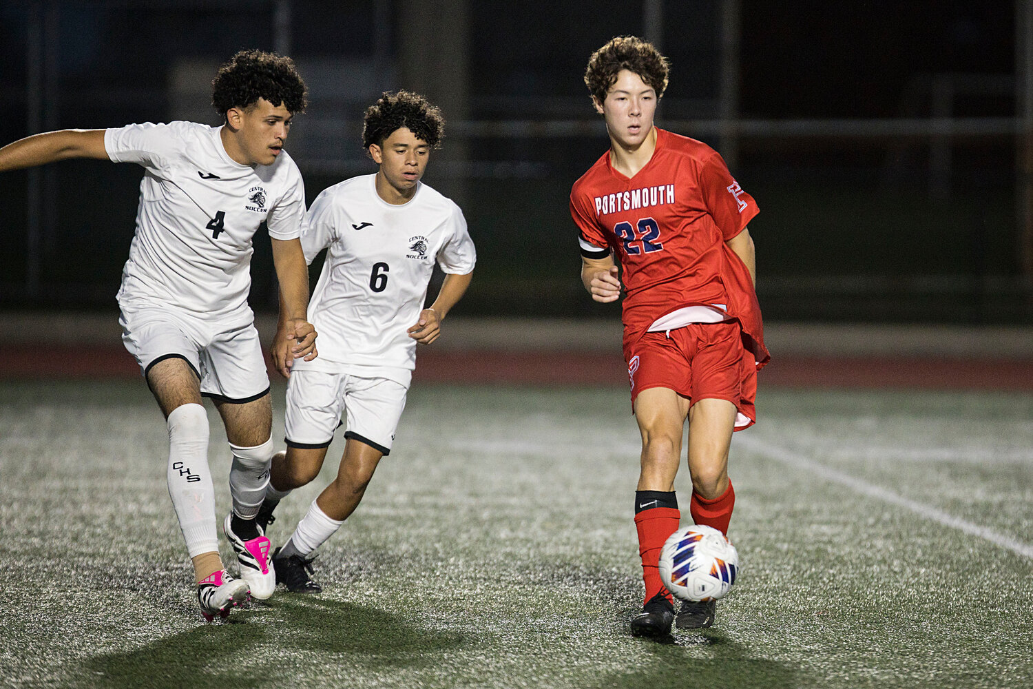 Aidan Chen dishes off a pass as a pair of Central defenders close in.