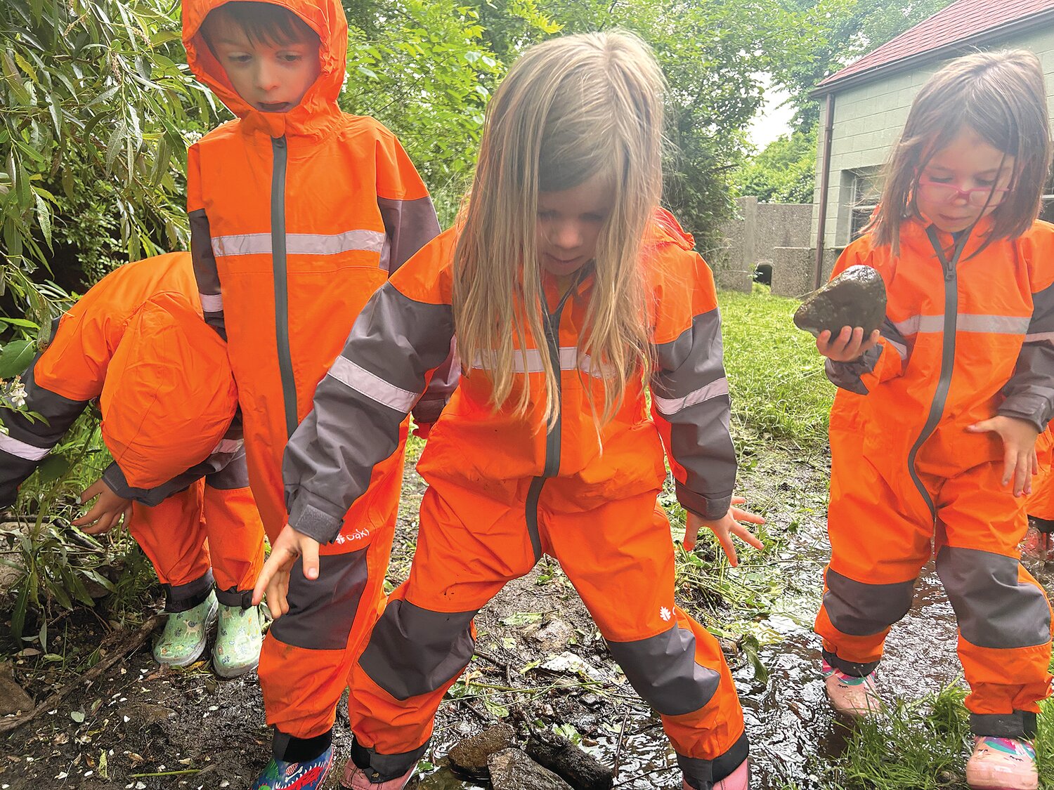 Gordon School puts a lot of emphasis on outdoor learning. Here, students in the lower grades, who all have rain suits and boots, explore the stream that runs through the campus on a rainy day.