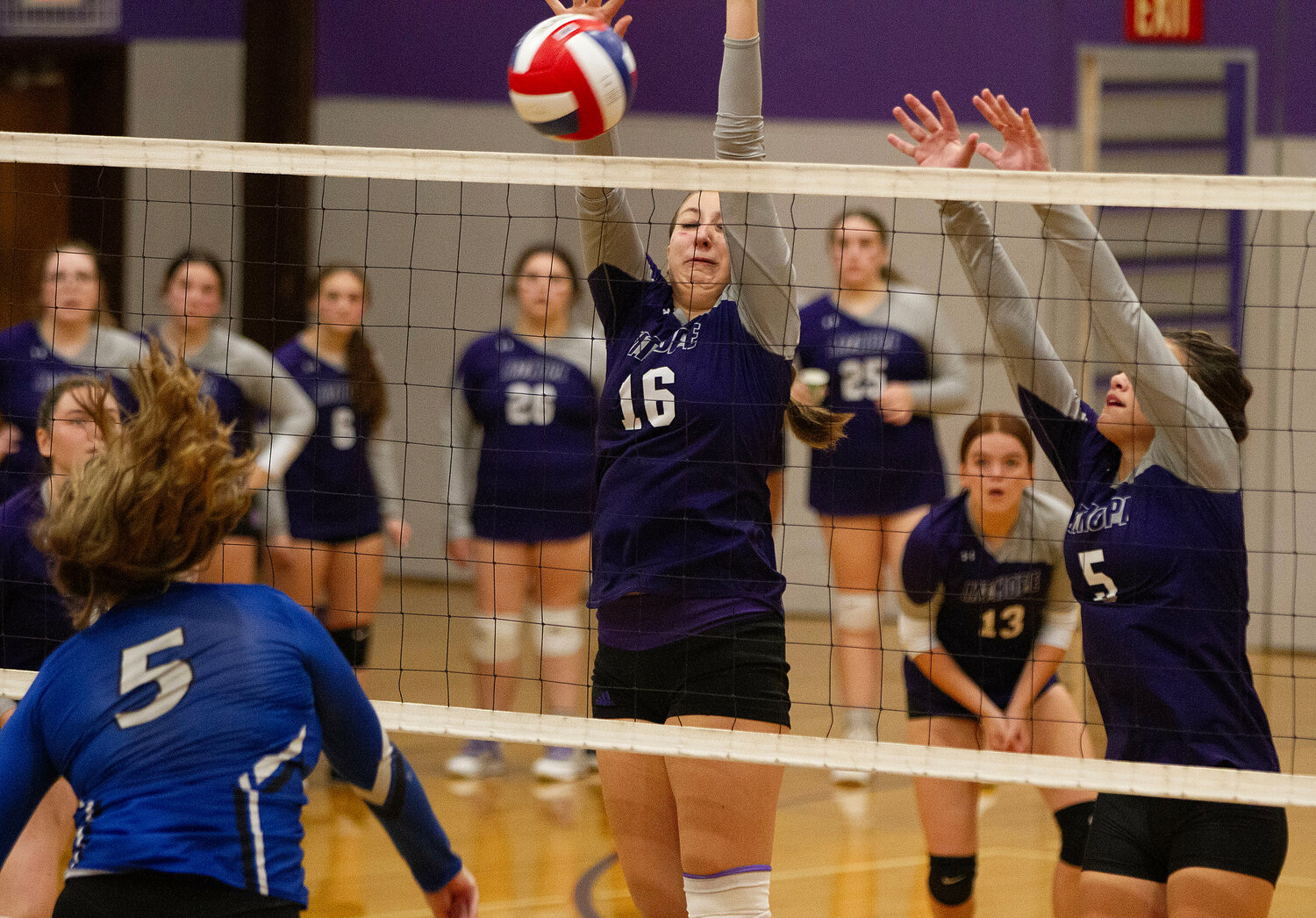 Abby Allen (left) blocks a Middletown slam with teammate Sarah Wilcox (right).