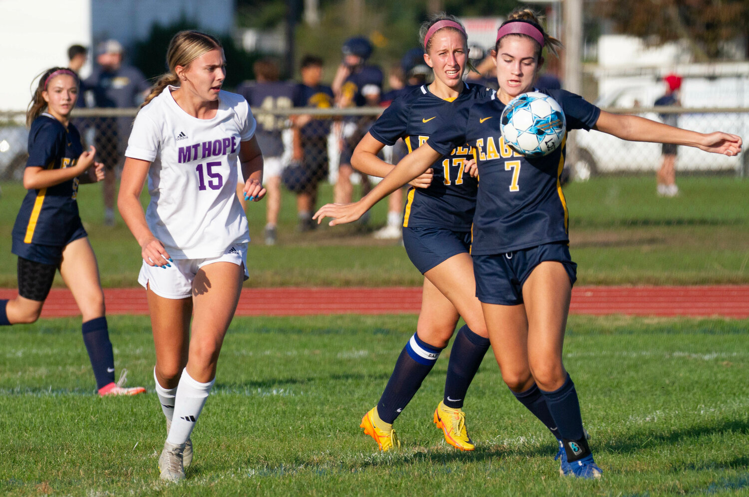 Lilly Swintak (mid-left) looks on as teammate Hannah Carlotto gathers a cross from a teammate.