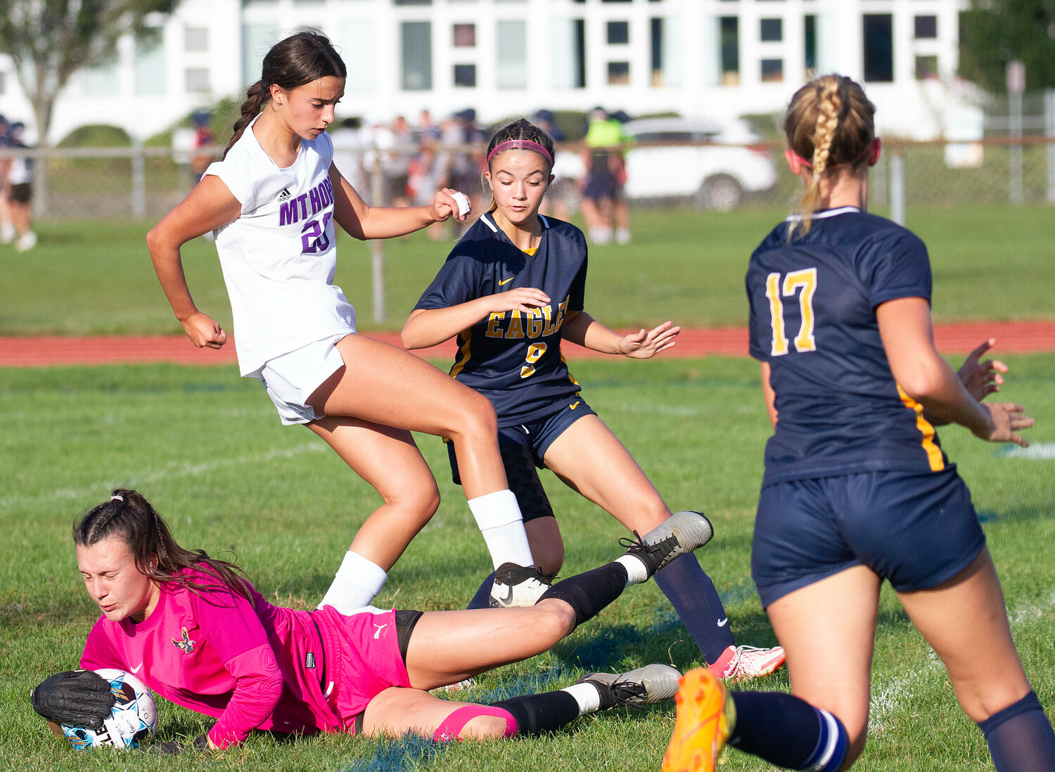 Barrington goalkeeper Maddie Gill dives to make a save on a through ball, before Huskies' striker Thea Jackson can get a foot on the ball. Barrington’s Makenzie Lema (left) and Lilly Swintak (right) look to help Gill.