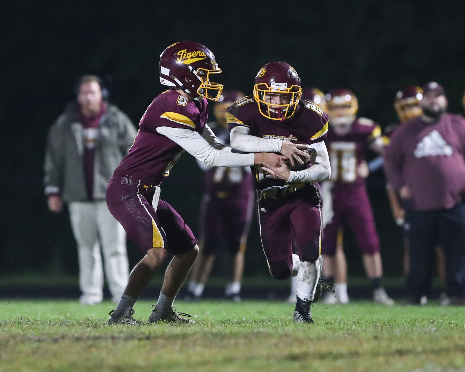 Quarterback Ben Troia (left) hands off to running back Evan Lapointe during the game.