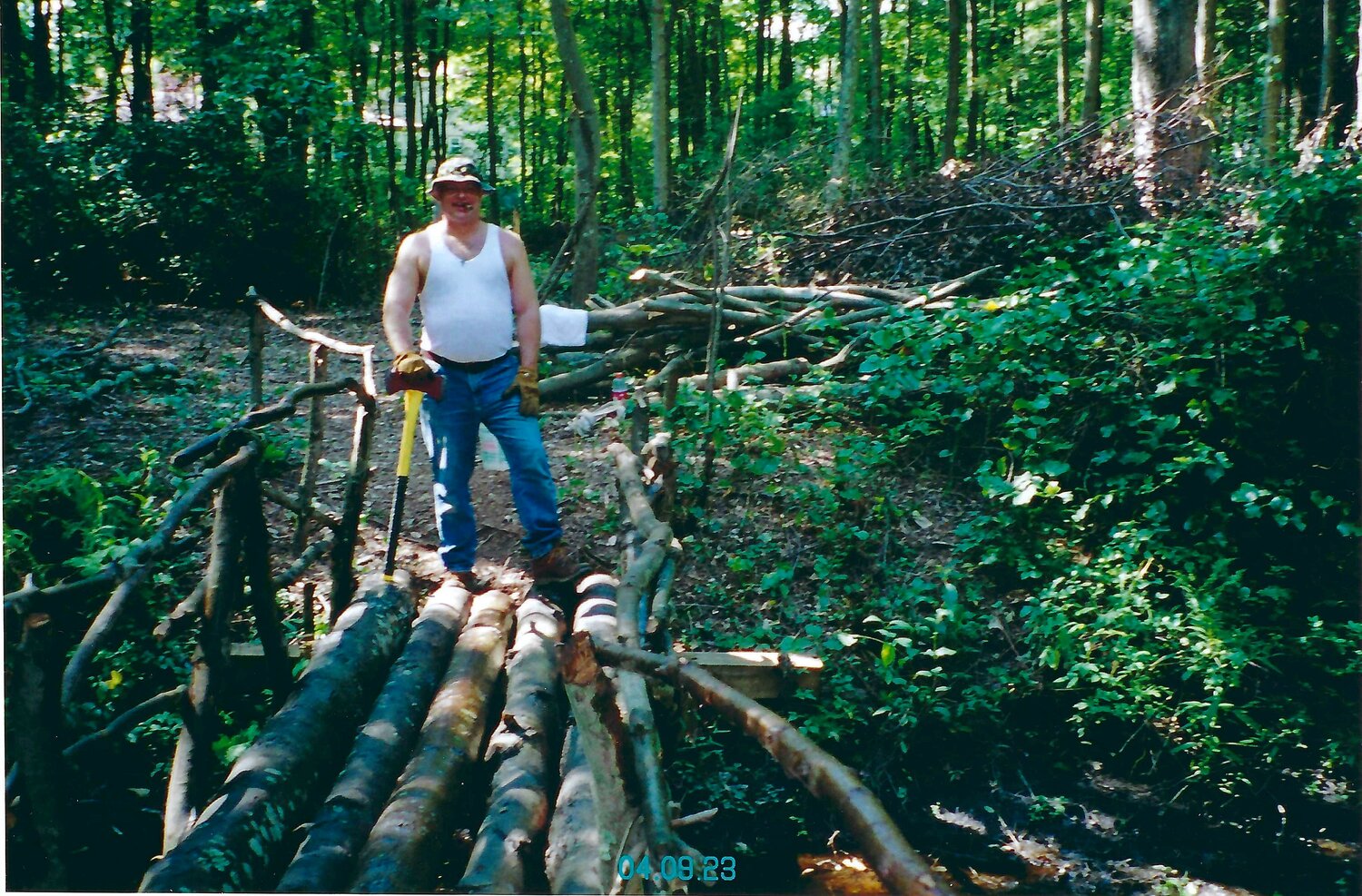 Paul Dziedzic, one of the eight siblings who grew up on the property, on a bridge he constructed years ago.