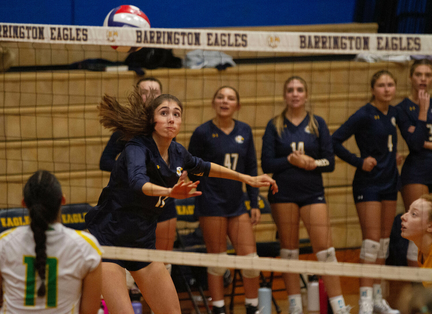 Barrington High School’s Ava Hentz sends the ball over the net.