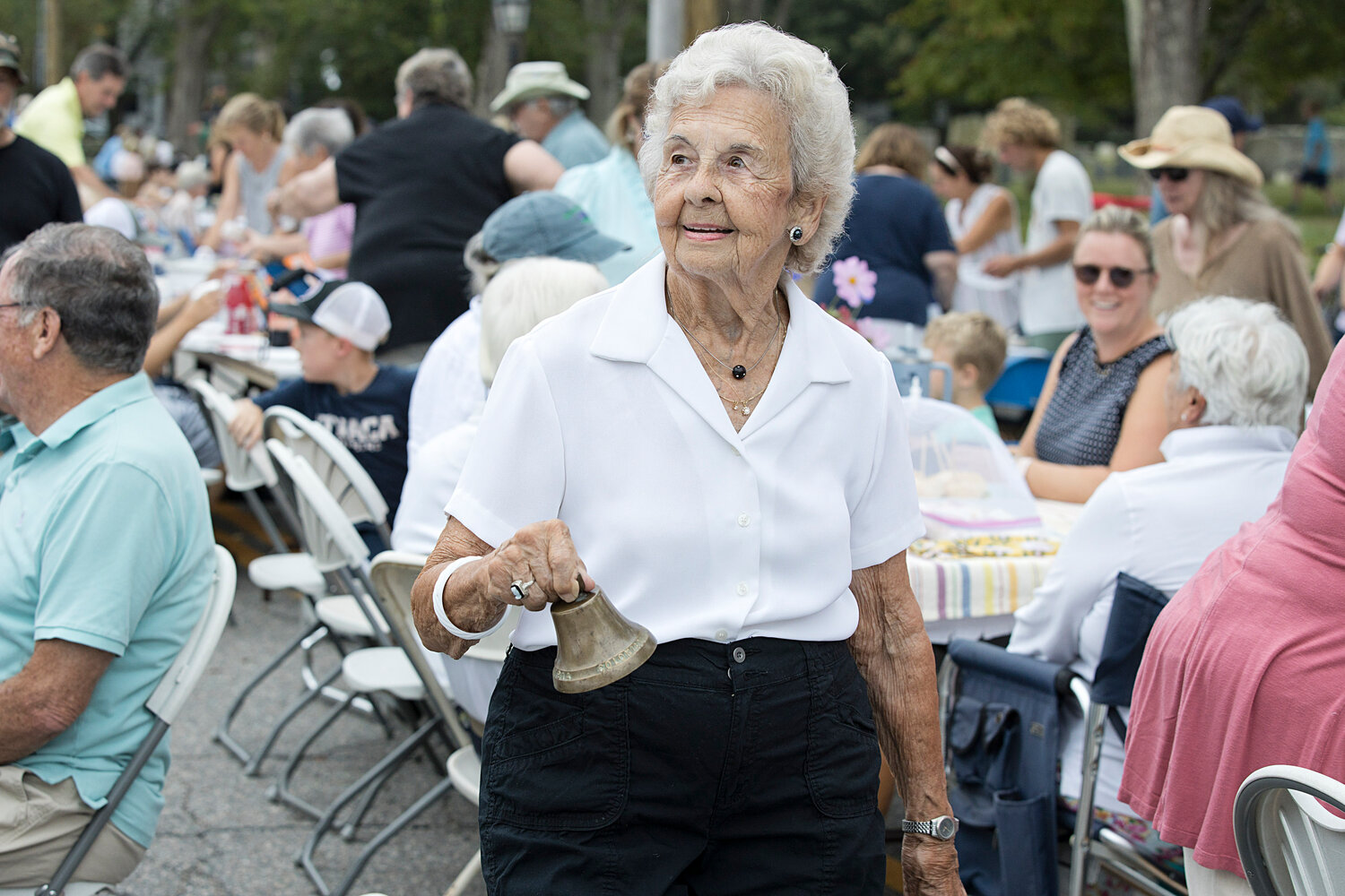 Barbara Passmore rings the dinner bell at this year's Little Compton Community Dinner, held last month.