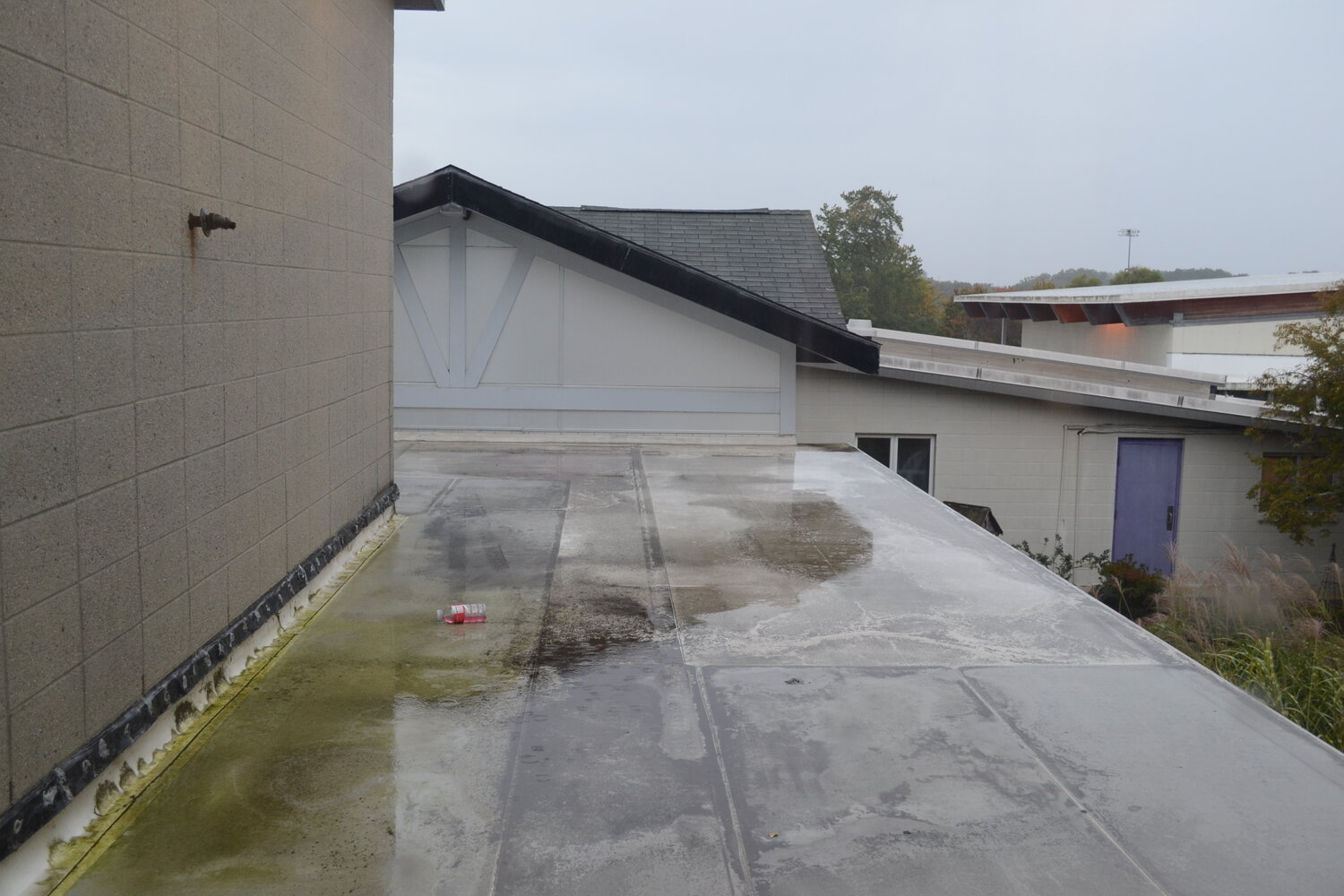 Water pooling on the roof can be seen from a window on the upper floor. Administrators and students alike say leaks are a nonstop occurrence throughout the year.