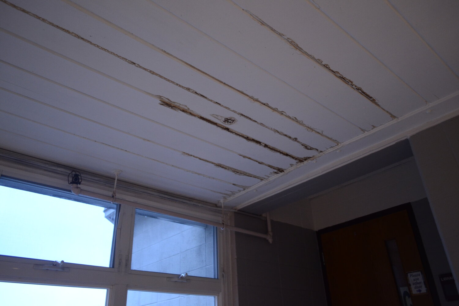 Water damage can be seen throughout the school along the ceiling, like this spot next to a window on the top floor.