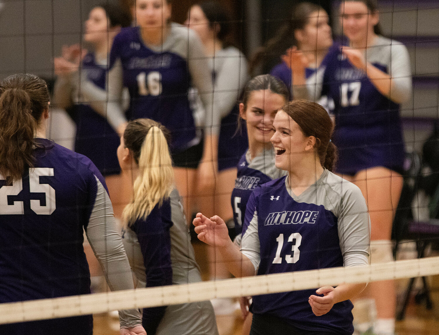Mia Shaw (right) celebrates with the team after a kill.