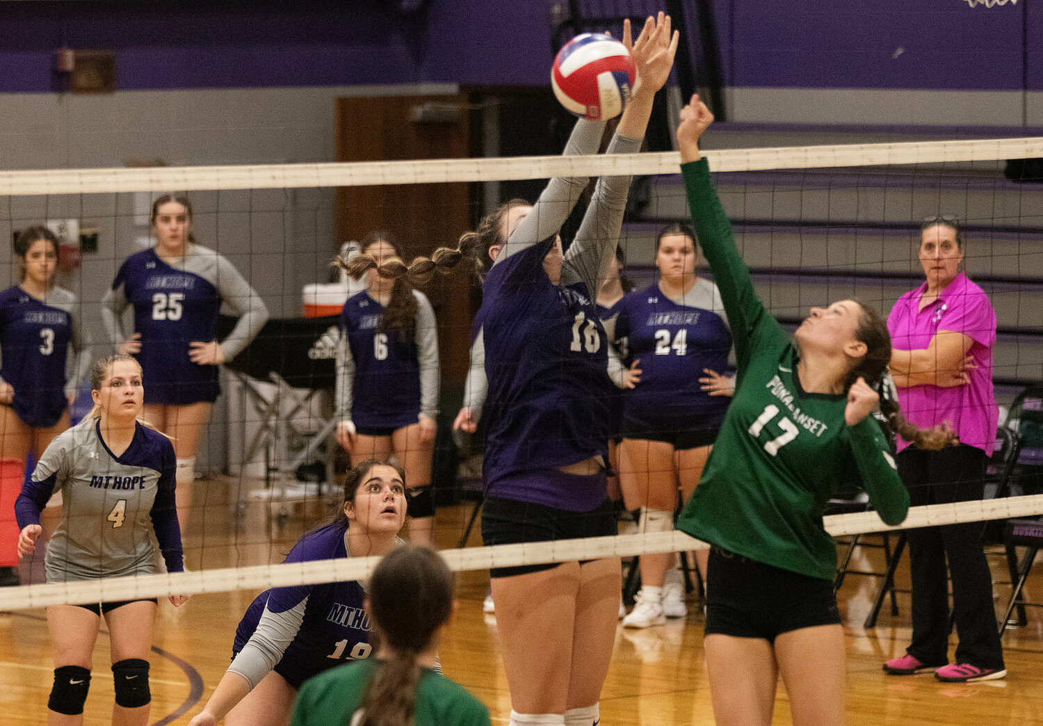 Mia Hanson (left) and Olivia Kenny look on as Abby Allen blocks a Ponaganset volley.
