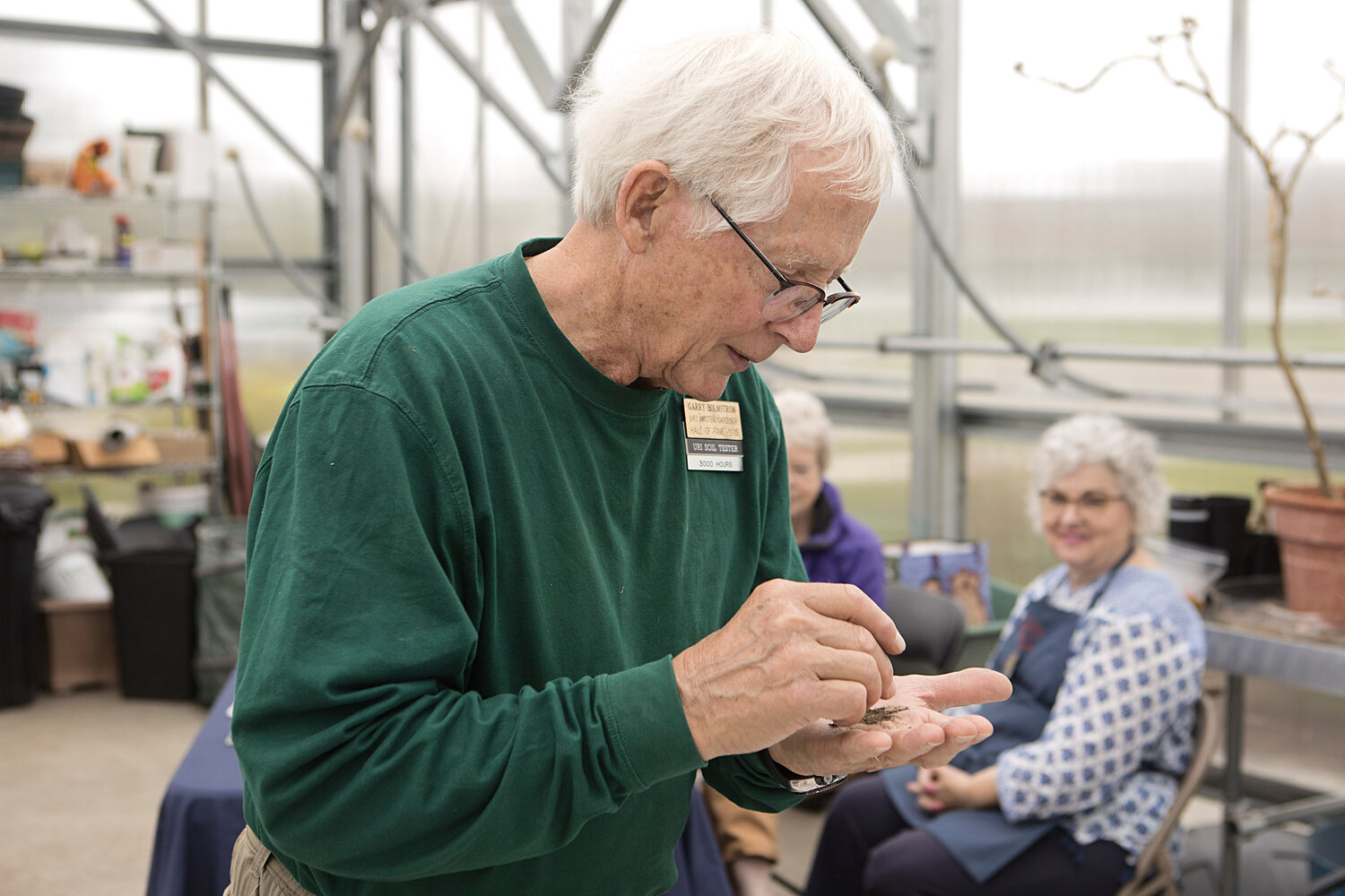 Garry Holmstrom examines soil inside the Veterans Home greenhouse.