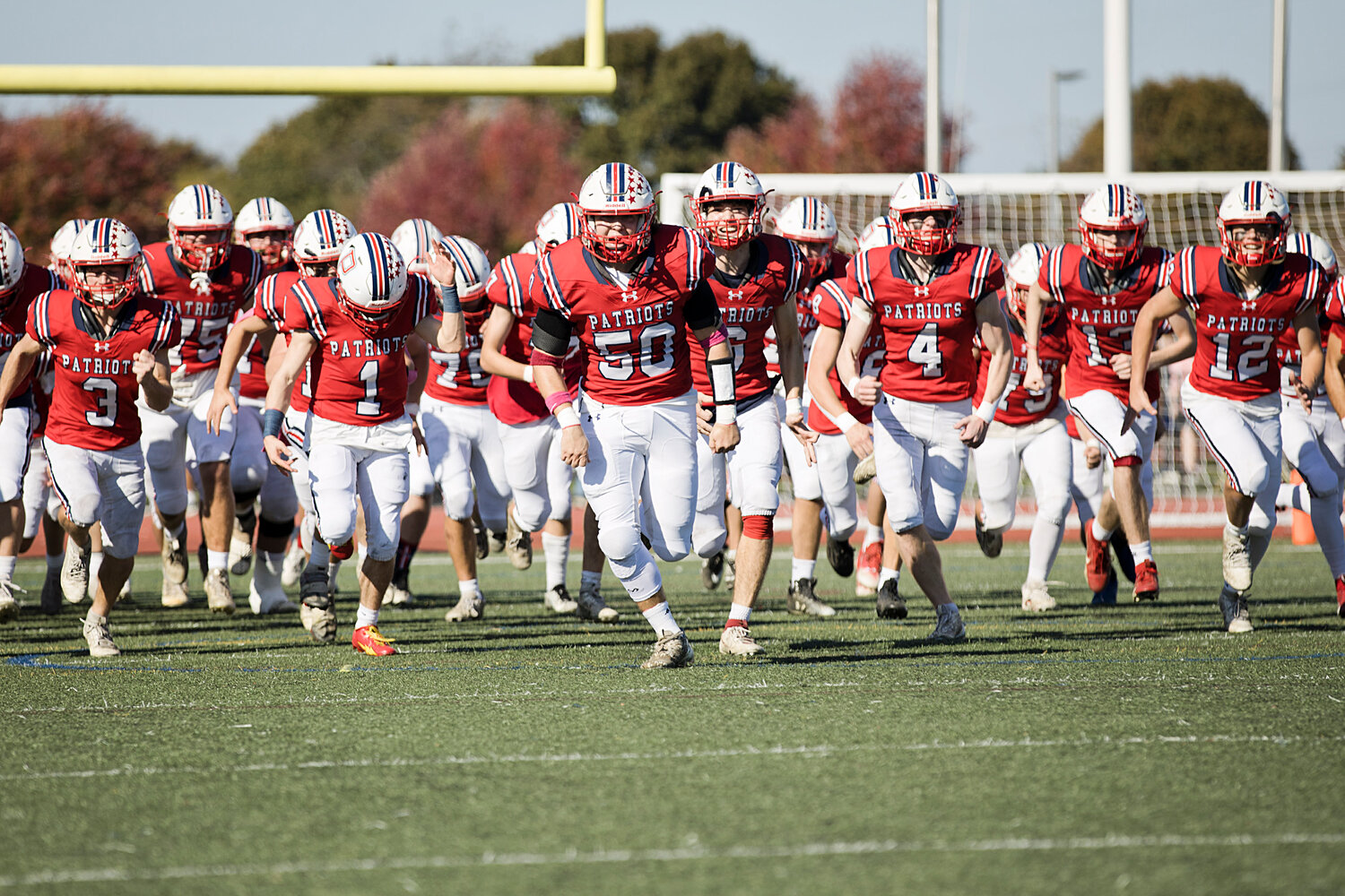 The Patriots take the field at the start of their homecoming game against Cranston East on Saturday.