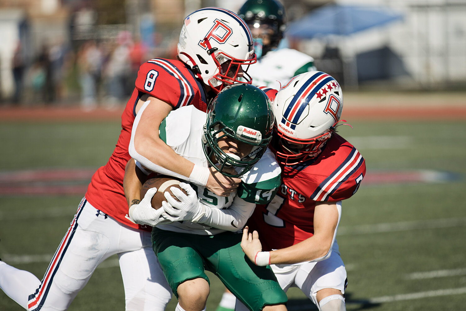 Tyler Hurd and Christopher Wilkie wrap up a Cranston East ball carrier.