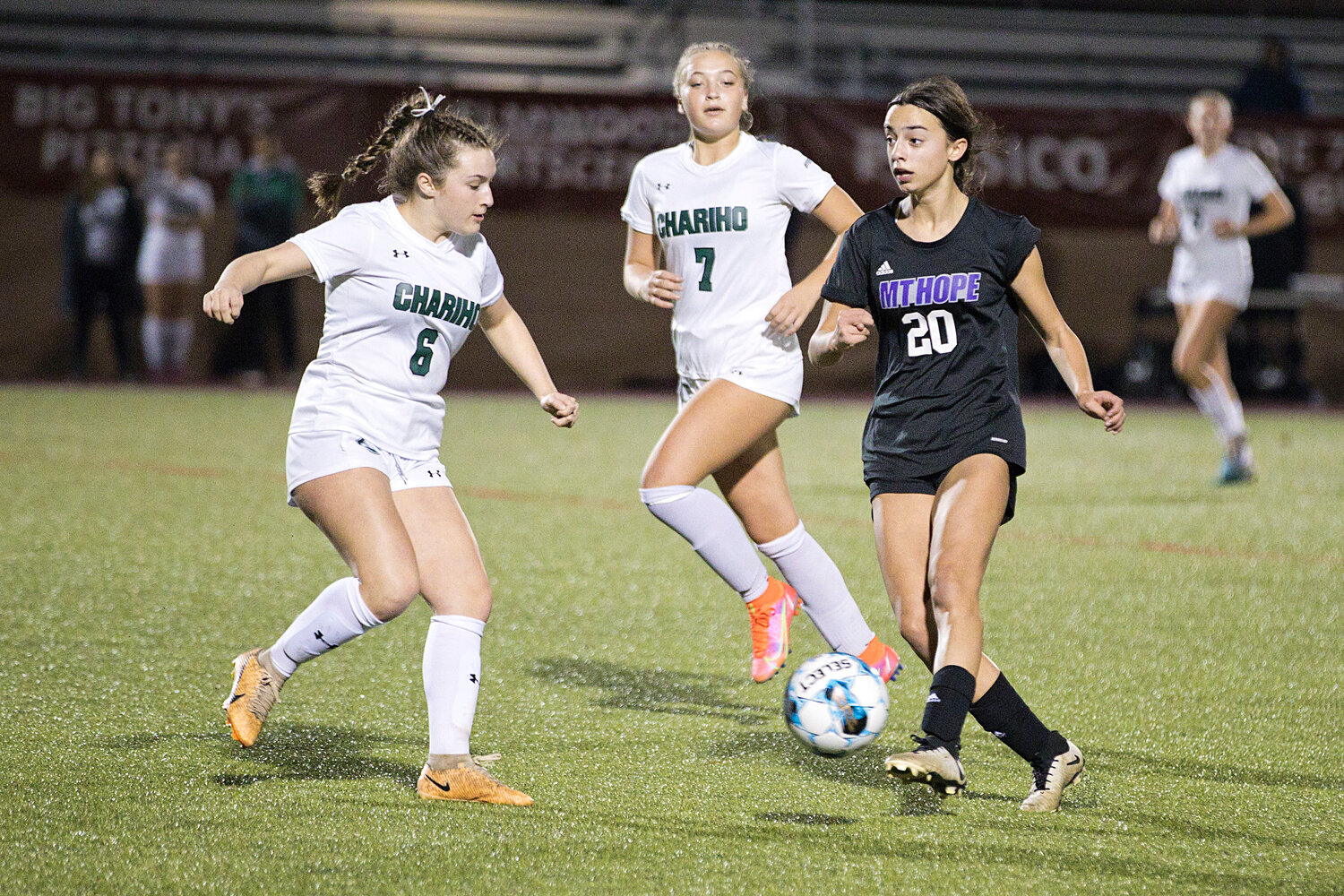 Thea Jackson looks for an open teammate as Chariho defenders close in.