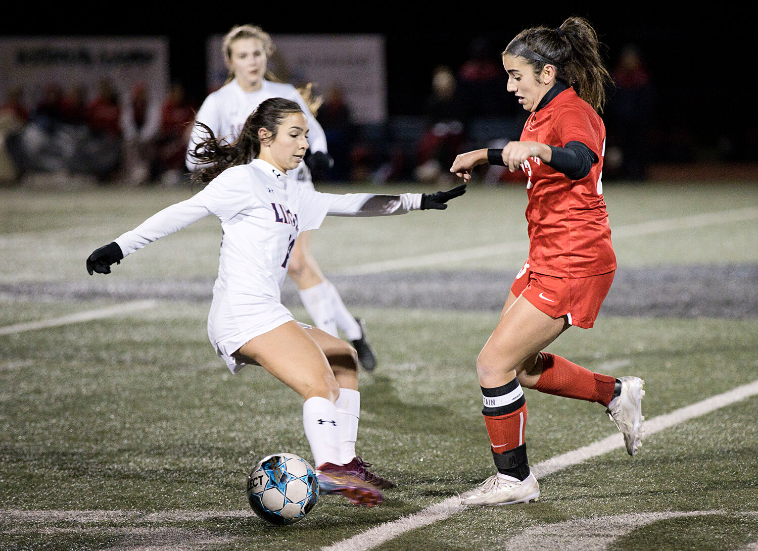 Sophia Karousos is pressured by a Lincoln opponent while advancing the ball.