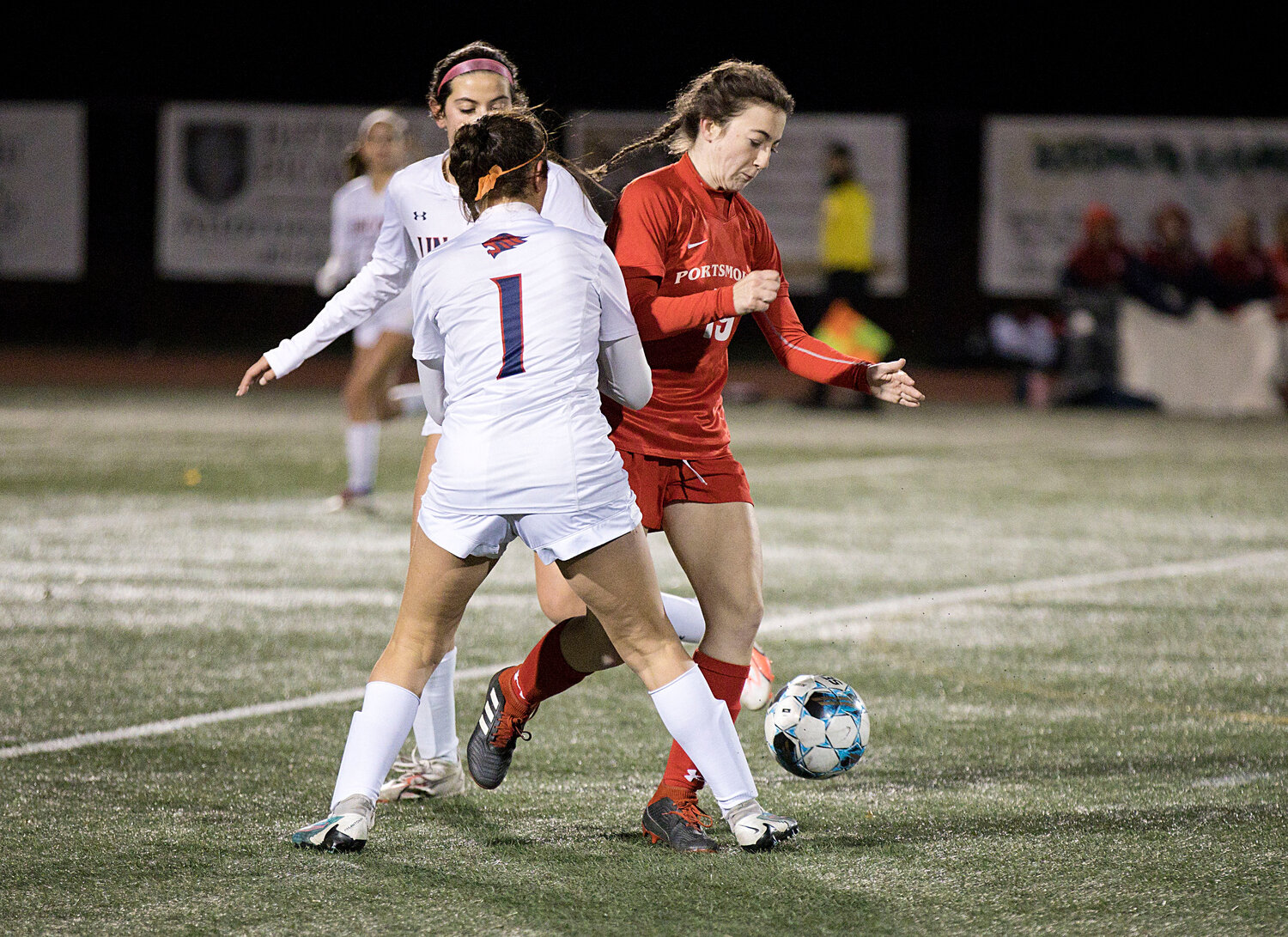 Claire Hook splits a pair of Lincoln opponents to advance the ball.