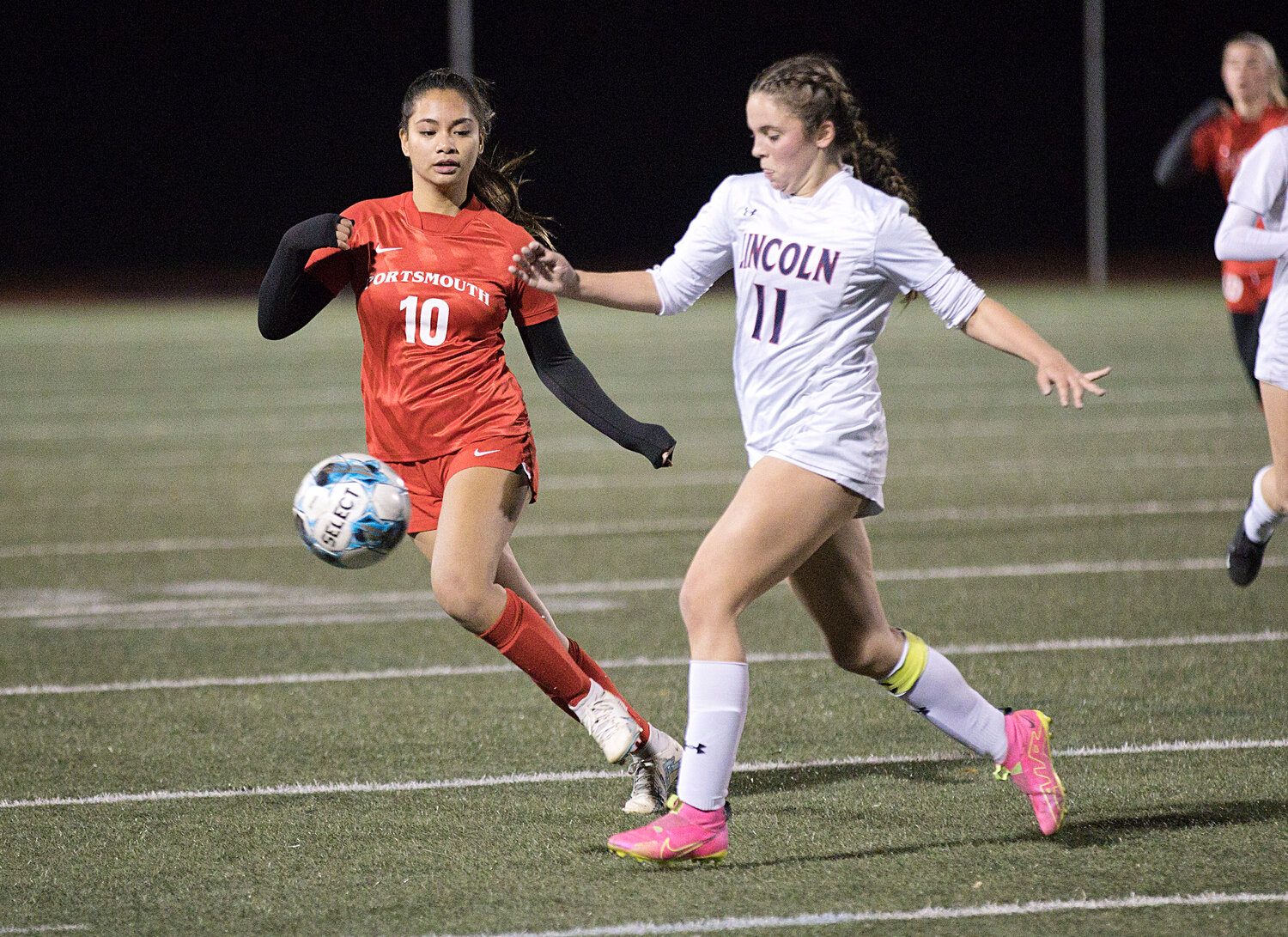 Kylie Delemos prevents a Lincoln opponent from turning toward the goal.