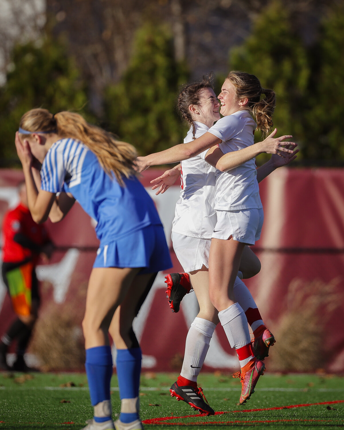 Claire Hook (left) and Lila Irwin celebrate their win as a Scituate player sinks her face into her hands.