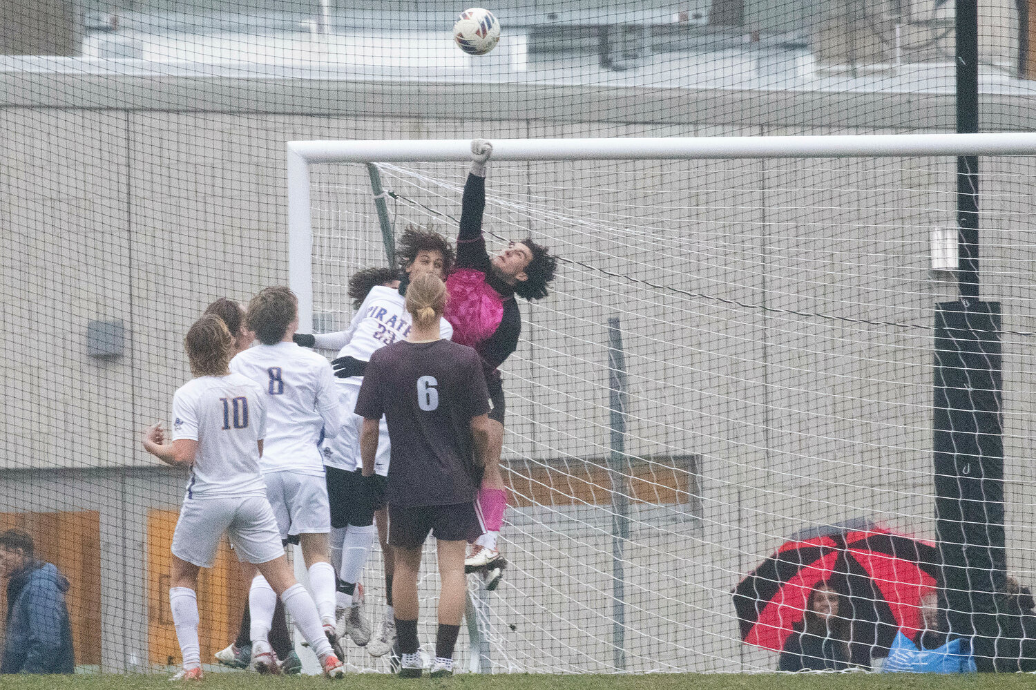 Goalkeeper Noah Amaral fists the ball out of the goal during a Hull corner kick.