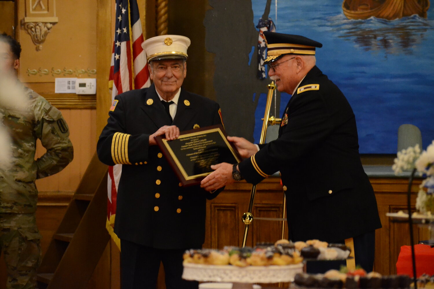 Former Warren Fire Chief and U.S. Navy veteran Al Galinelli receives his commendation and plaque from David Foehr of the Warren Historic Armory Board of Directors.