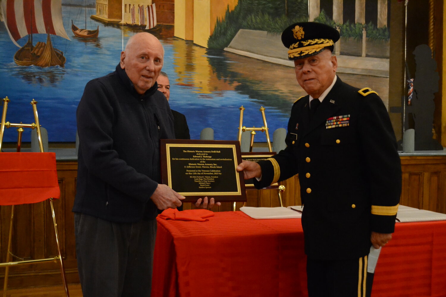 Edward Theberge, who has been a volunteer and active advocate for The Warren Armory for decades, receives a plaque and learned that the hall where the ceremony was taking place would be named after him.
