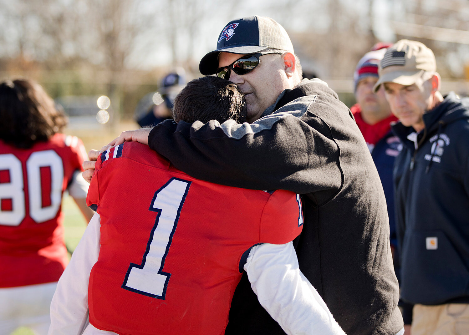 Head coach Keith MacDonald hugs Aidan Maisen while sharing a moment with each player after the game.
