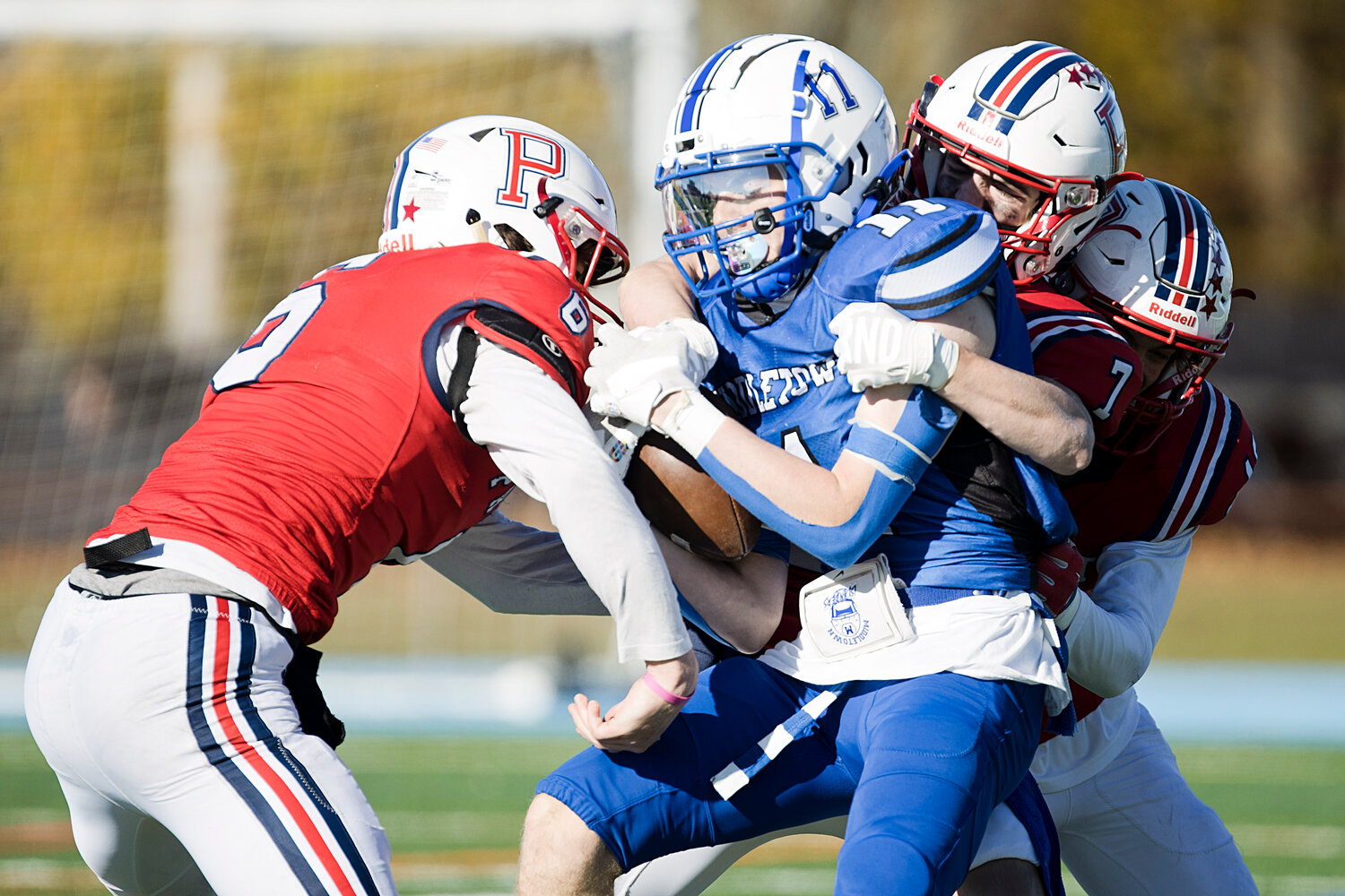 Tyler Hurd, Christopher Wilkie, and Stephen Ramponi, tackle a Middletown running back.