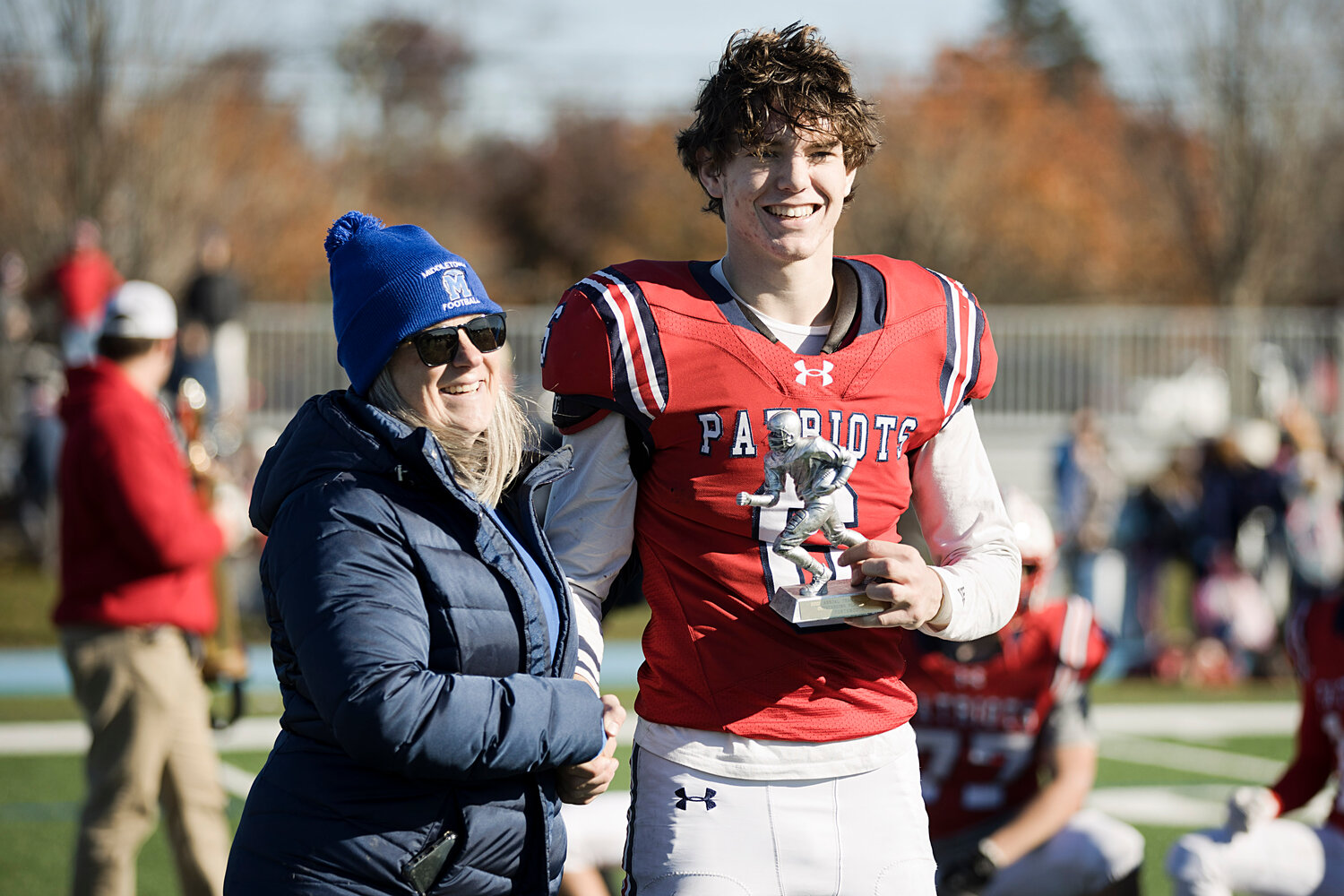 Middletown High School Principal Donna Sweet awards the Patriots’ Tyler Hurd with the game MVP trophy during the awards ceremony following the contest.