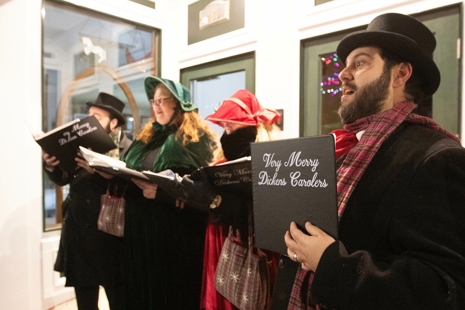 The Very Merry Dickens Carolers sing under an awning on Main Street.
