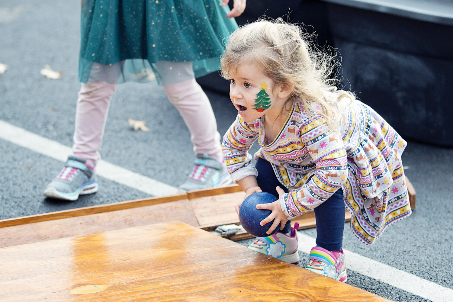 Lyla Boylan takes aim while playing a game of snowman bowling at the tree-lighting event on Saturday, Dec. 2.