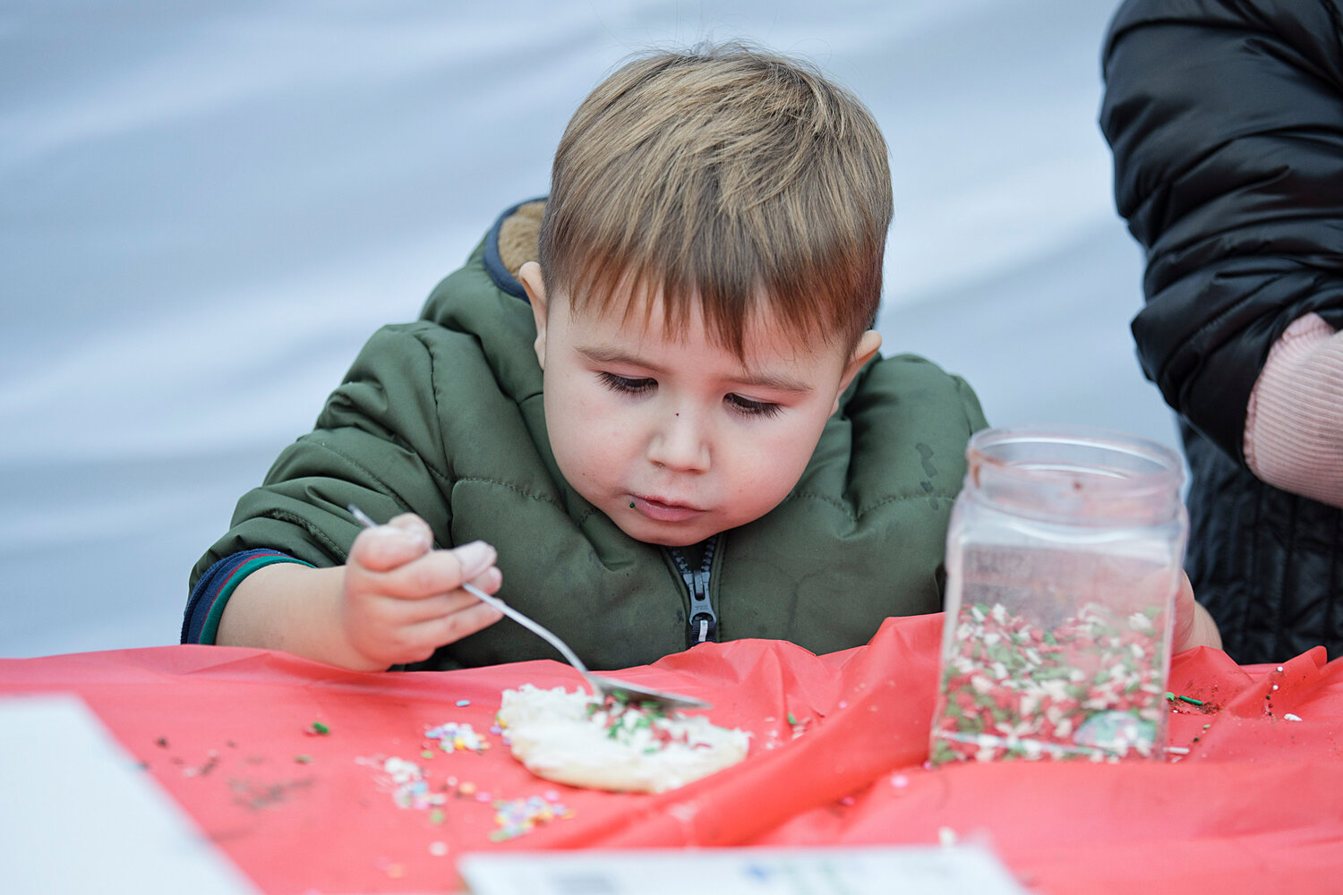 Nemesio Rio carefully adds sprinkles while decorating a cookie at the tree-lighting event on Saturday, Dec. 2.