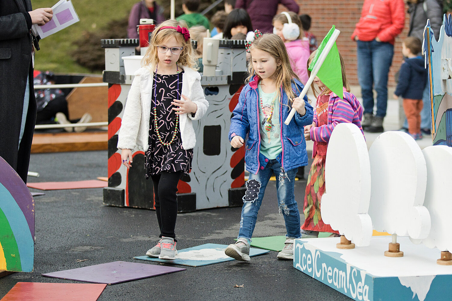 Madalyn Hadfield (left) and Madeline Miller take their turn while playing a life-sized game of Candy Land at the tree-lighting event on Saturday, Dec. 2.