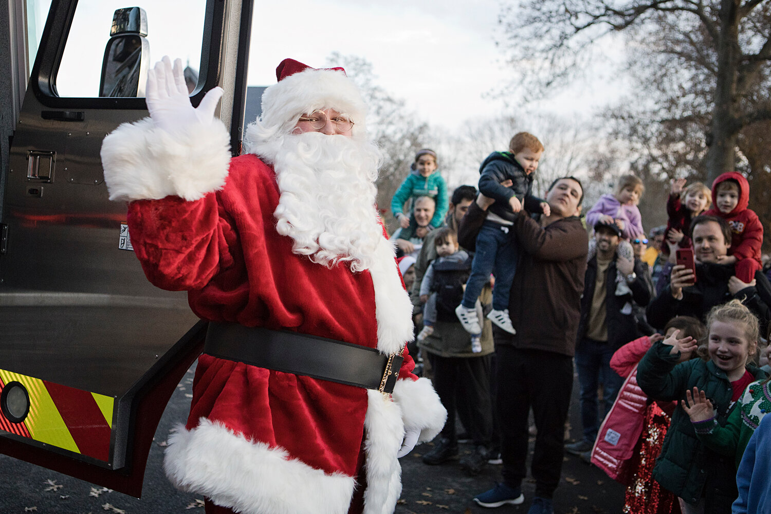 Santa waves to the crowd as he climbs out of a fire truck, at the tree-lighting event in Barrington on Saturday, Dec. 2.