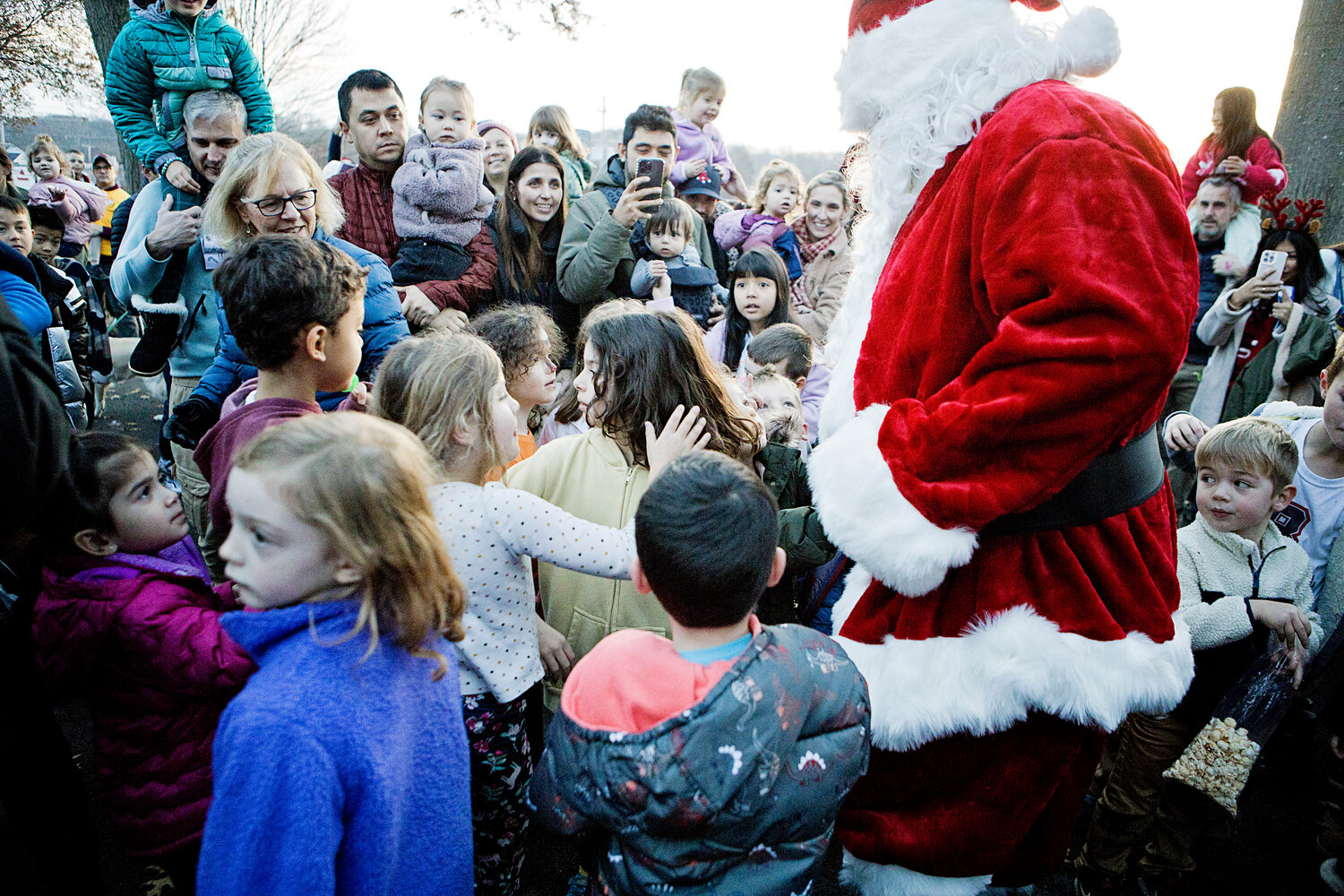 Children mob Santa as he arrives at Barrington Town Hall, Saturday, for the tree-lighting event.