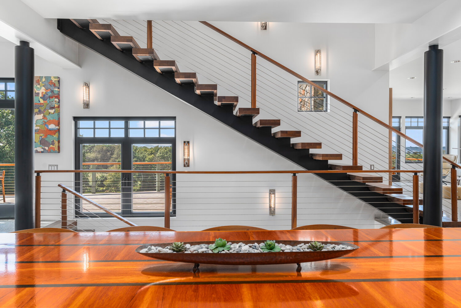 A staircase connecting the main level to the upper level is “floating,” with a steel beam supporting custom teak risers.