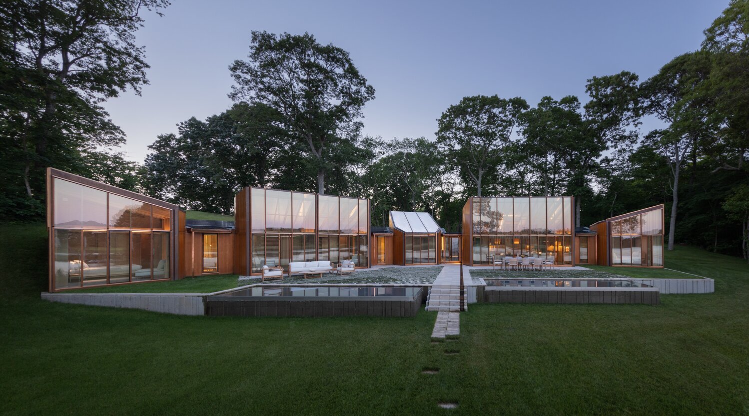 This view shows all five pavilions, with “guest” bedrooms to the left, main living space in the center, and master bedroom to the right. The entire structure is designed in a crescent shape, so it gently wraps around and encloses the terrace.
