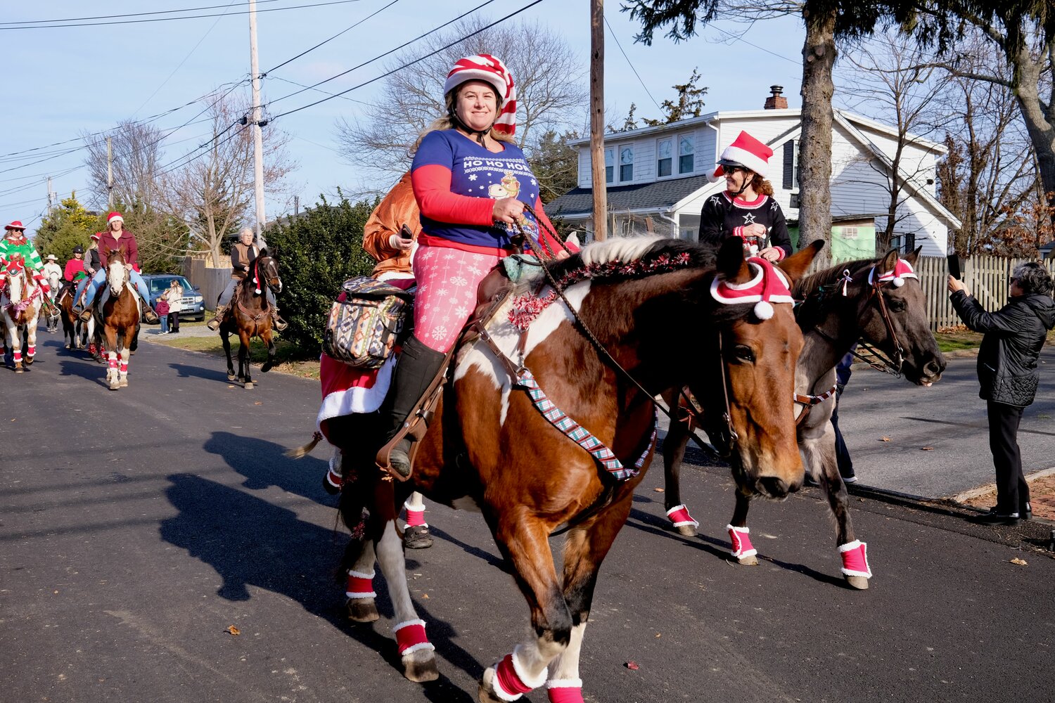 A festive-looking Jen Jackson (foreground) and Candy Ferreira ride their horses through the neighborhood.
