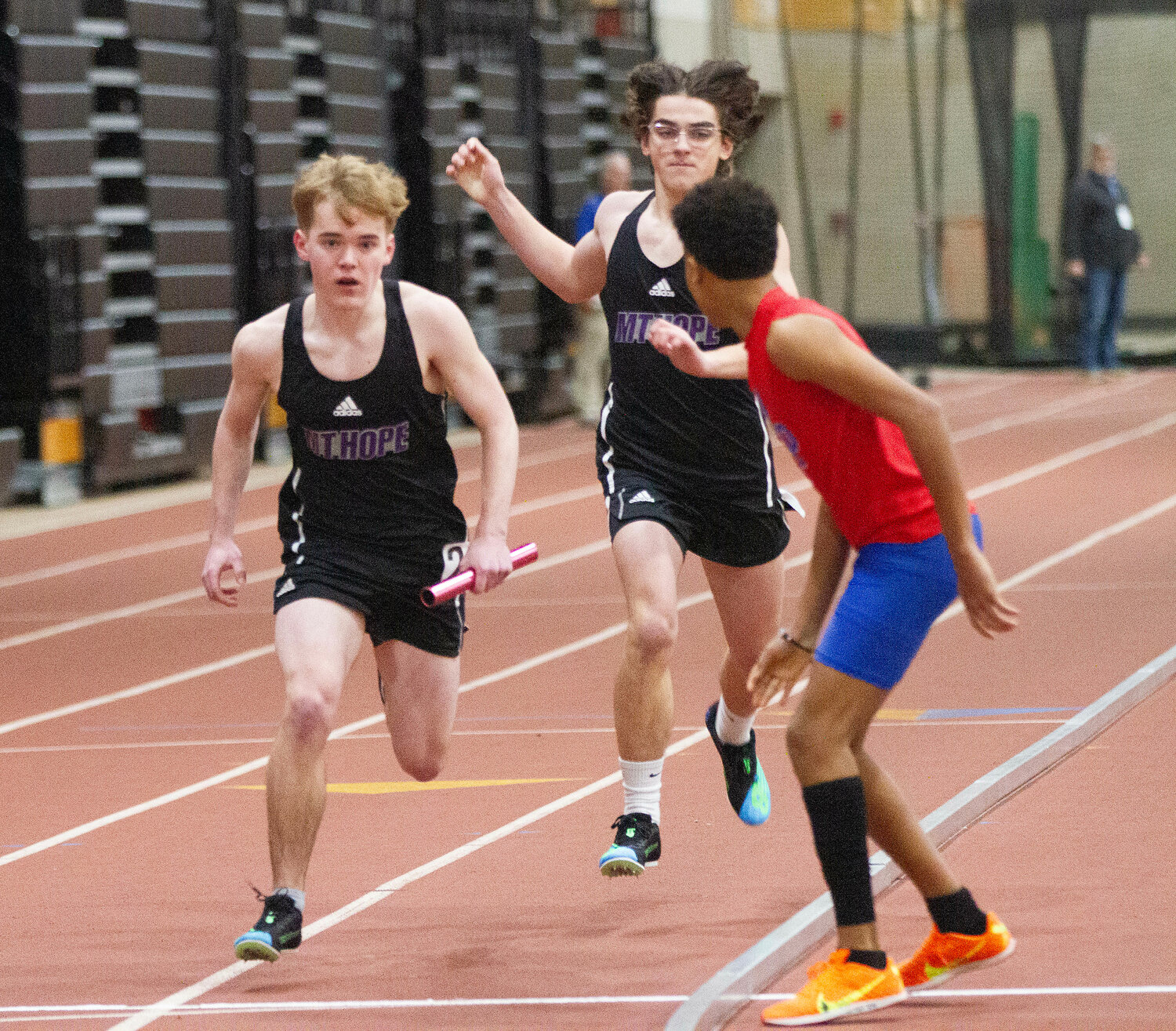 Chris Moniz (middle) hands the baton to Tyler Scarborough (left) during the 4x200 meter relay.