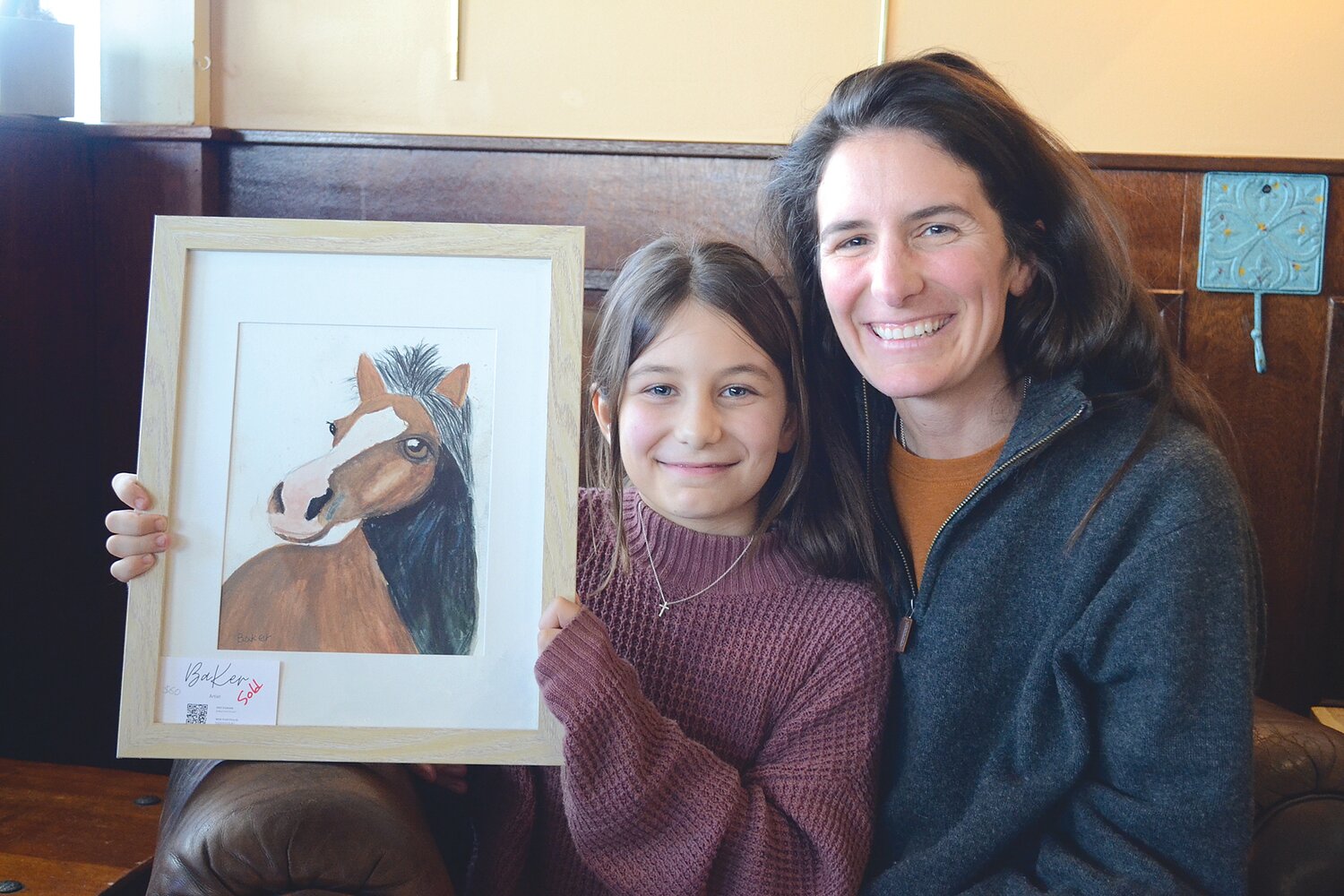 Baker Smith, 9, and her mom, Jen, pose with one of Baker’s favorite pieces of artwork at the Coffee Depot on Monday afternoon.