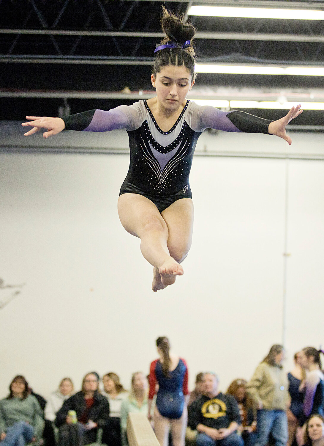 Madeleine St. Pierre executes a stunt on beam during Sunday's meet against Portsmouth.